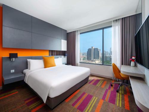 曼谷曼谷暹罗美居酒店的酒店客房设有一张大床和一张书桌。