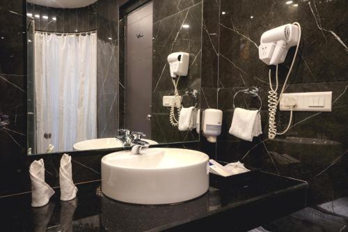 布巴内什瓦尔帕尔高地酒店的一间带水槽的浴室和墙上的两部电话