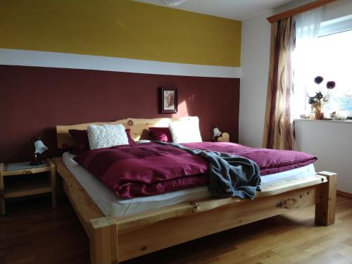 GrainetFerienwohnungen Christa Grabmeier的一间卧室配有一张带紫色床单的木床
