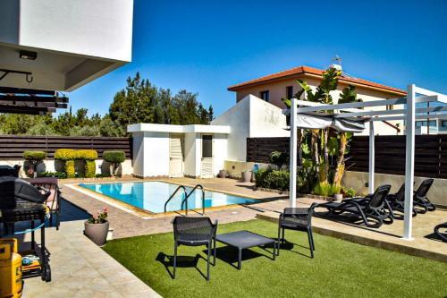 拉纳卡Ilios Villa的后院设有游泳池、椅子和房屋