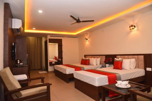 达尔瓦德M R Residency Dharwad.的酒店客房设有两张床和一张桌子。