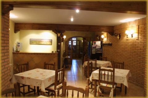 别尔赫CASA RUFAS (Sierra de Guara)的一间设有桌椅的用餐室和砖墙