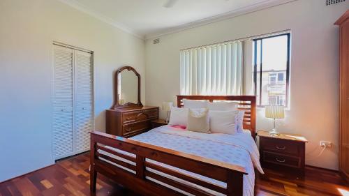 悉尼Carlton 3 beds unit - free parking的一间卧室配有一张大床和镜子