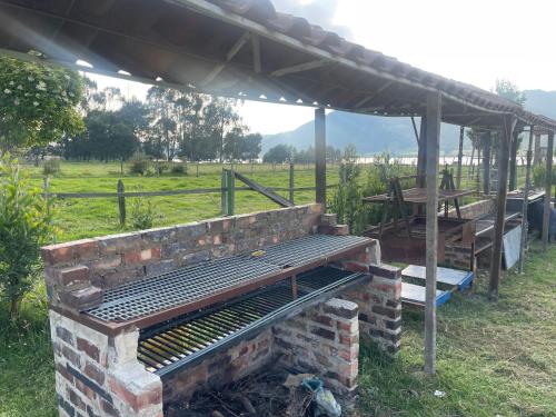 苏埃斯卡Glamping Naturaleza - mirador de la laguna de suesca的野地凉亭下的砖块烧烤