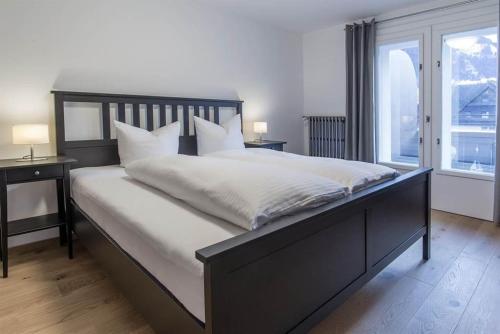 施伦斯Haus Kapell的一间卧室配有一张带白色床单的大床