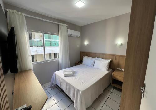 弗洛里亚诺波利斯Ilha Forte Praia Hotel的一间小卧室,配有床和窗户