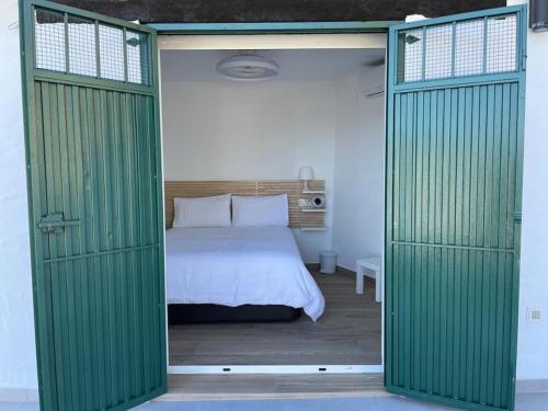 蒙达The Nook at Monda的一间卧室配有一张带绿色推拉门的床