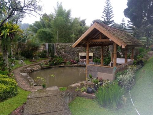 展玉Villa kaca 88的花园内带池塘的凉亭