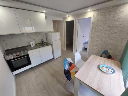 阿利坎特SDH apartments的厨房配有白色橱柜和桌椅