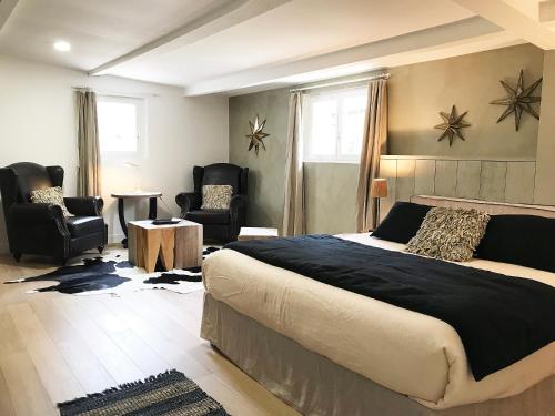 圣保罗-德旺斯Bastide Nomade - Charming B&B的一间卧室配有一张大床和两把椅子