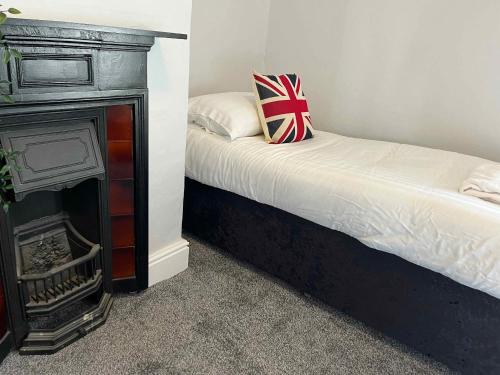圣亚萨The North Wales Gathering - Hot Tub & Sleeps Up To 16的一间卧室配有一张床和一个壁炉