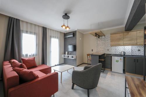 博德鲁姆İNCİ BOUTİQUE APART的一间带红色沙发的客厅和一间厨房