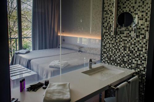 赫尔特山谷赫尔特旅馆的一间带水槽的浴室和一张带镜子的床
