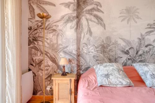 博尔马斯·莱斯·米默萨斯Bel appartement classé 3 étoiles的一间卧室配有一张棕榈树壁纸的床