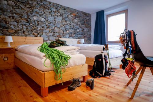 艾罗洛Bed&Bike Tremola San Gottardo的一间卧室设有两张床和石墙