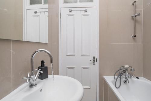 伦敦Kensington Nest Serviced Town House的白色的浴室设有水槽和镜子