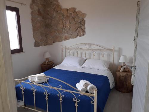 帕基诺Casale Tano的一间卧室配有一张带蓝色床单和白色枕头的床。