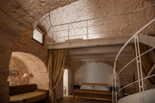 阿尔贝罗贝洛Le Alcove - Luxury Hotel nei Trulli的一间卧室配有一张石墙双层床