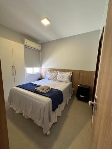 巴西利亚Flat em Brasília - Moderno e equipado的一间卧室配有一张带蓝色毯子的大床