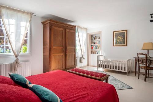 ÉpégardCottage 4 chambres avec cheminée的一间卧室配有红色的床和木制橱柜