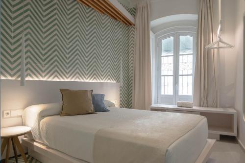 科尼尔-德拉弗龙特拉La Casa del Arco的卧室配有一张床,位于带检查墙的房间内