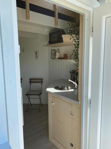 格林斯泰兹Kroghs Tiny Houses - Hyttebyen的厨房配有水槽和带椅子的台面
