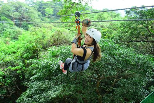 利比里亚Buena Vista del Rincón Eco Adventure Park Hotel & Spa的森林中一个高空滑索上的女人