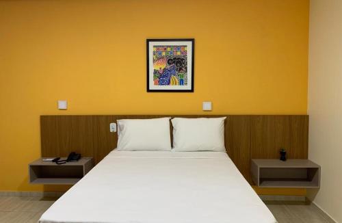 圣路易斯Boulevard Park Hotel的卧室配有白色床和黄色墙