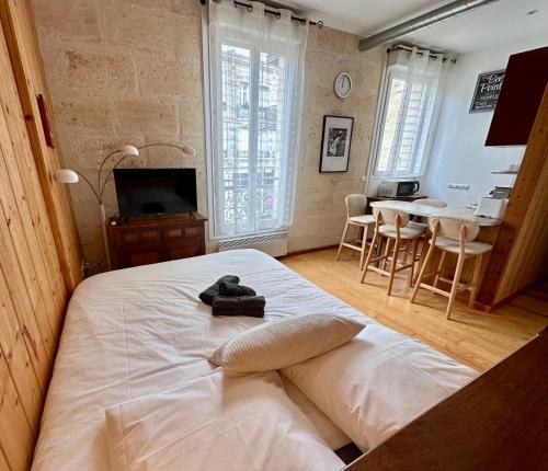 波尔多Le Woody, Centre-ville, Parking gratuit的卧室配有白色的床和桌椅
