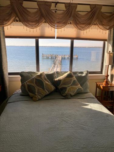 纳瓦拉Romantic Island condo for 2 - Sunset Harbor 1-205 - Navarre Beach的一张带枕头的床,位于大窗户前