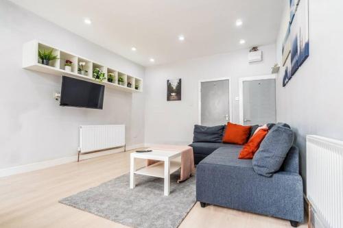 伯明翰Lavish 2- bedroom Flat with Free Parking的客厅配有蓝色的沙发和电视