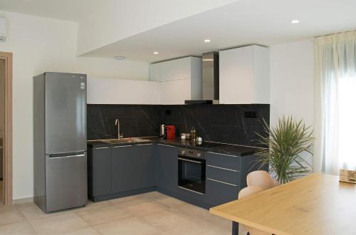 阿吉亚特拉萨天使湾公寓的厨房配有蓝色橱柜和不锈钢冰箱