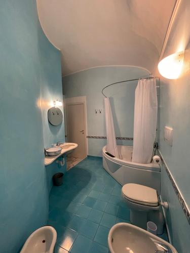 托伊拉诺Bed & Breakfast Scià Dina的浴室配有2个卫生间、浴缸和水槽