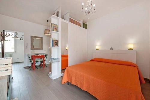 罗马L'Attichetto di Ponte Milvio的一间卧室配有橙色的床和桌子