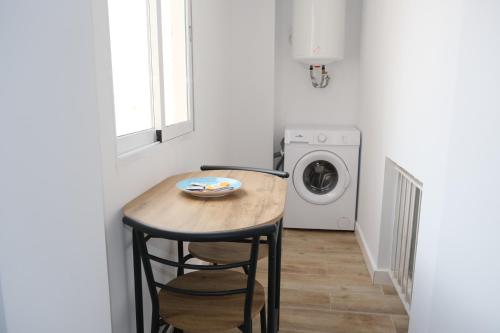 阿利坎特SDH apartments的一间带桌子和洗衣机的小厨房