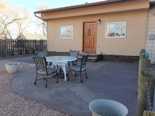 科罗拉多斯普林斯Your home in Colorado Springs的房屋前设有带桌椅的天井。