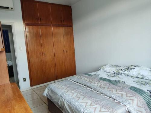 戈亚尼亚Apartamento 2 quartos Setor Sul的一间卧室配有一张床和一个木制橱柜