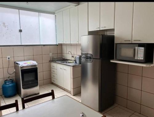 戈亚尼亚Apartamento 2 quartos Setor Sul的厨房配有不锈钢冰箱和微波炉。