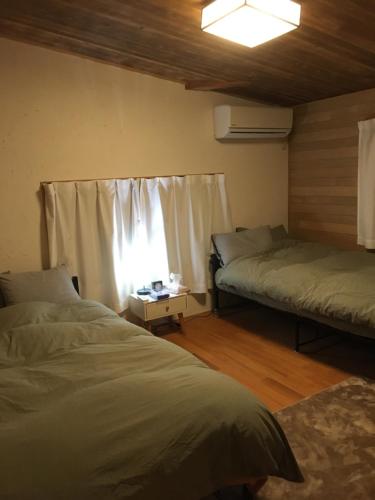 InamiMOMO HOUSE的一间卧室设有两张床和窗户。