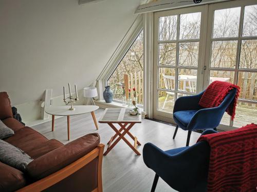 KlagstorpYogi Wellness Guesthouse的带沙发、椅子和窗户的客厅