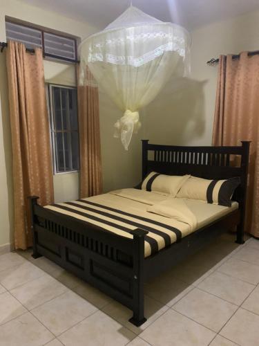 GuluLarry's Place - Gulu , Uganda的床上床,带窗帘和床罩