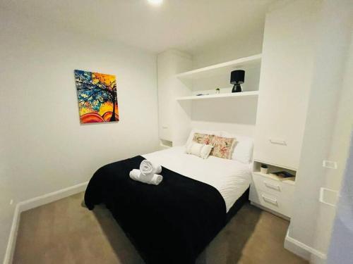 墨尔本City Haven with Breathtaking Views的卧室配有一张床,墙上挂有绘画作品