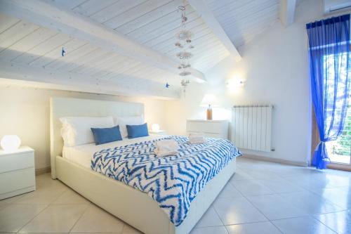滨海弗兰卡维拉AbruzzodAmare Amazing Apartments with Romantic Sea View的一间卧室配有一张带蓝色和白色棉被的床