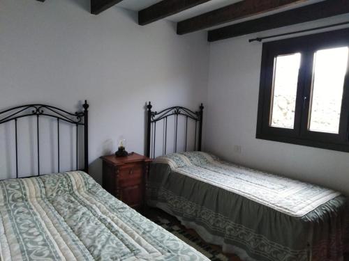 Las RosasCasa Ben Abora的一间卧室设有两张床和窗户。