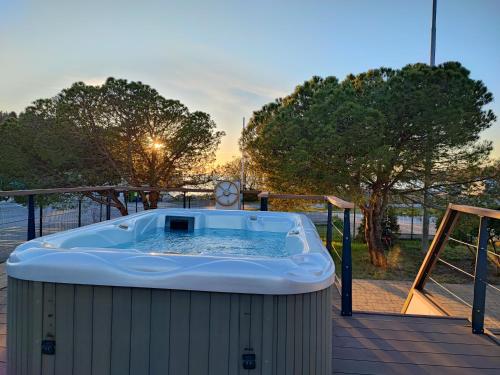波尔托罗SEA LUX FLOATING HOUSE AJDA Portorose的甲板上的热水浴池,享有日落美景