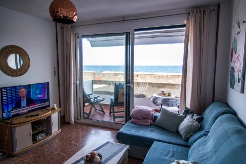 洛思坎加约斯Mar y Sol的客厅配有蓝色沙发,享有海景