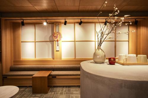京都Miru Kyoto Gion的一间房间,里面摆放着桌子和花瓶