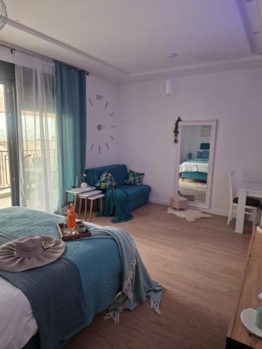 特雷比涅Kathisma Trebinje的一间卧室配有蓝色的床和沙发