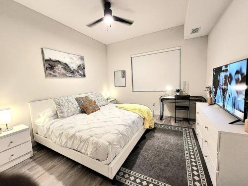 西棕榈滩Luxe & cozy 3Beds,2rooms,EV Gym Near Beaches&Downtown WPB的一间卧室配有一张床和一台平面电视