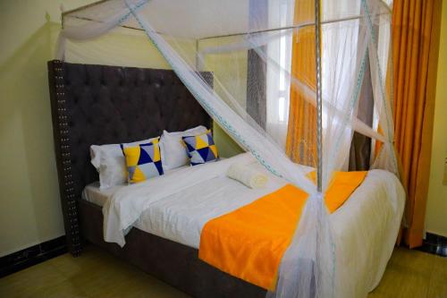 Langata RongaiSpringStone executive suite Rm 2的一间卧室配有一张带天蓬的床